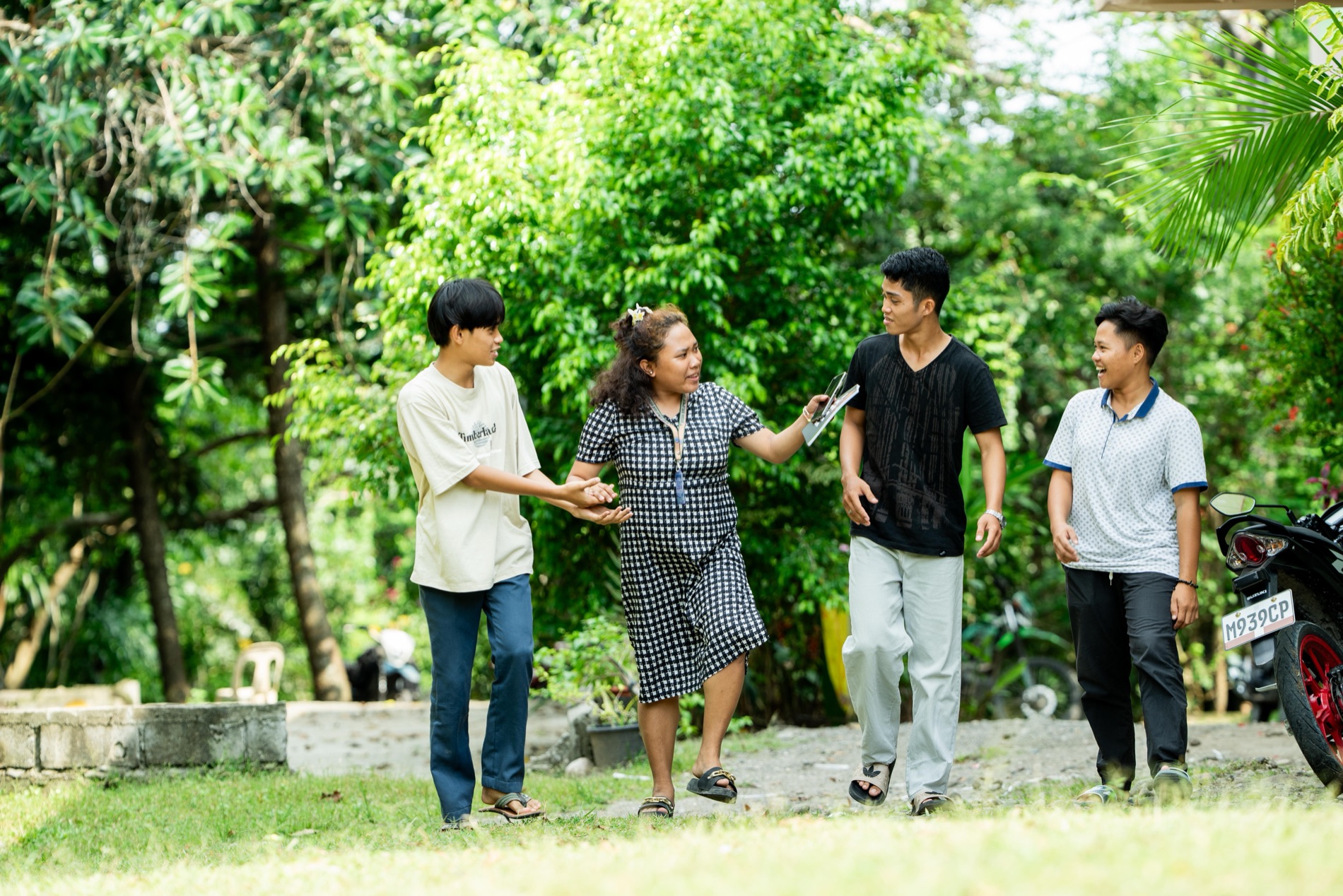 A woman laughing with young people outdoors in Mindanao
