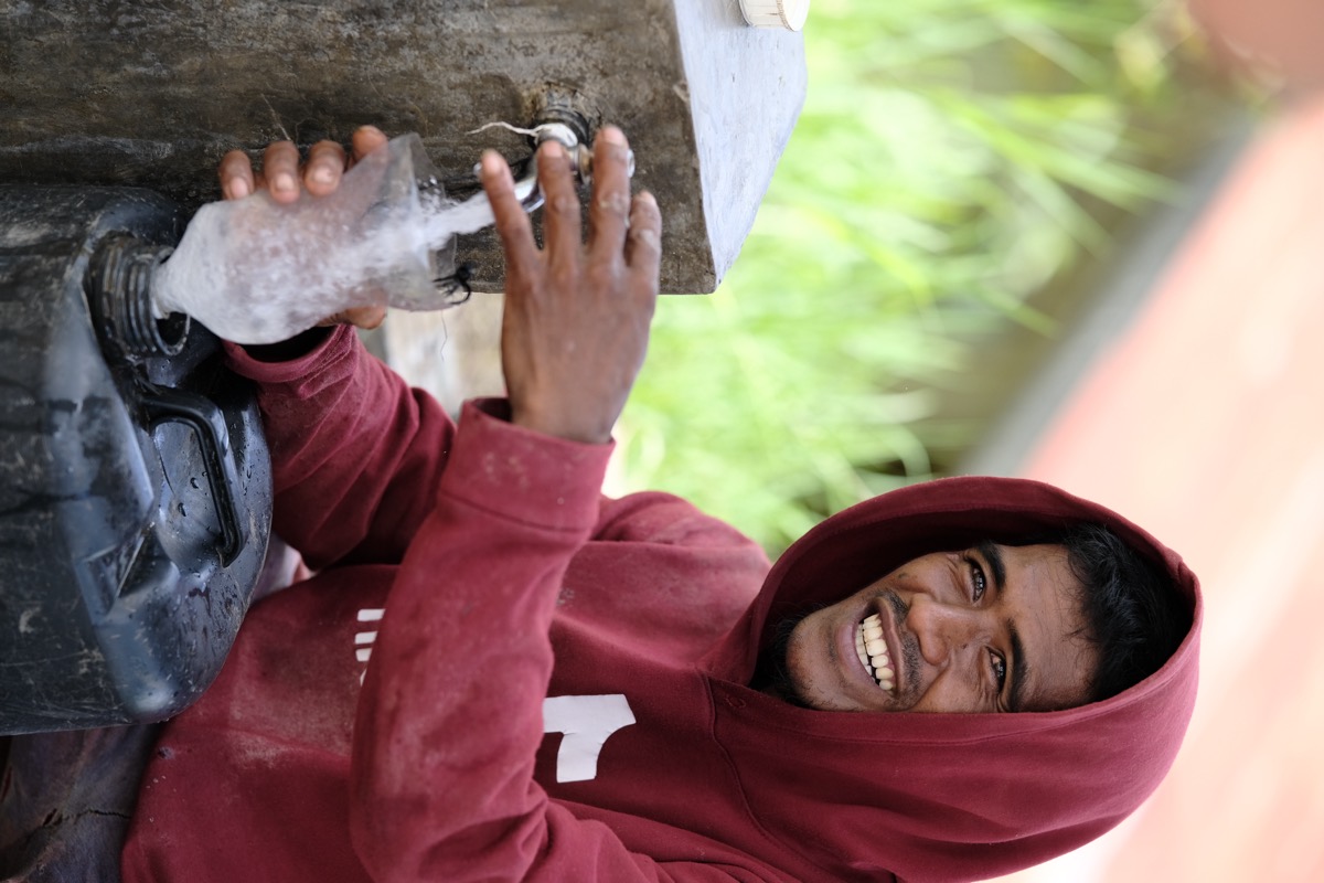 A man laughing as he fills water in Mindanao