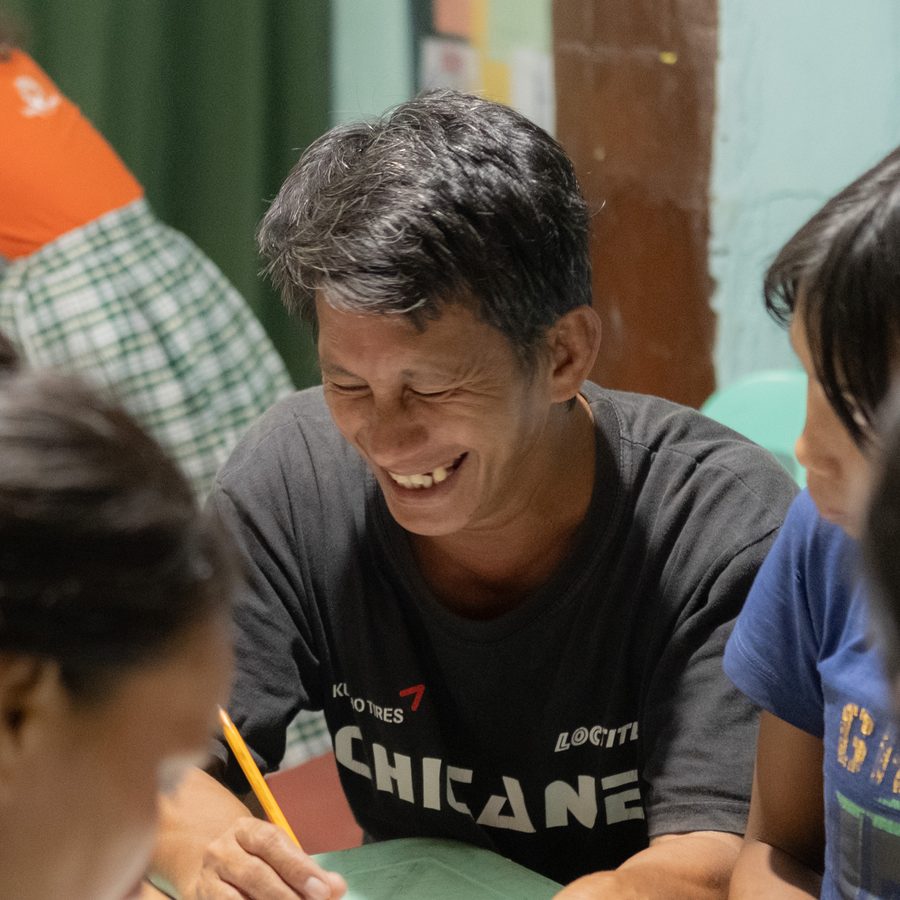 A father laughing during a literacy class