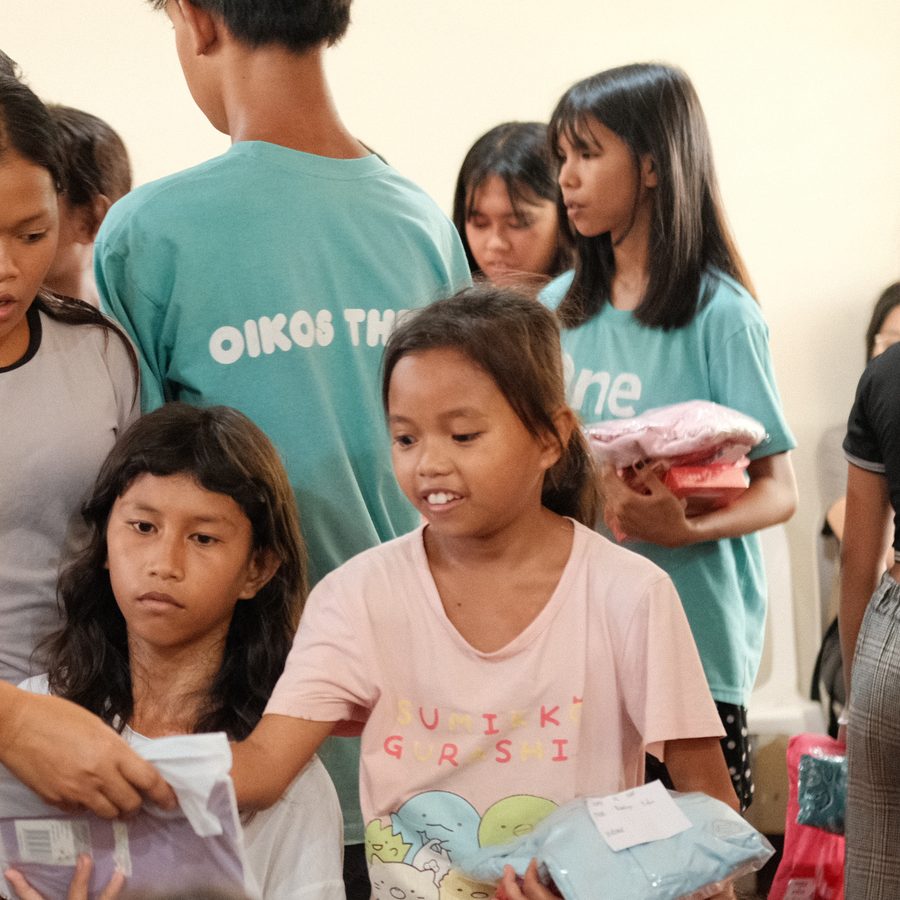 A young girl smiling as she receives a gift