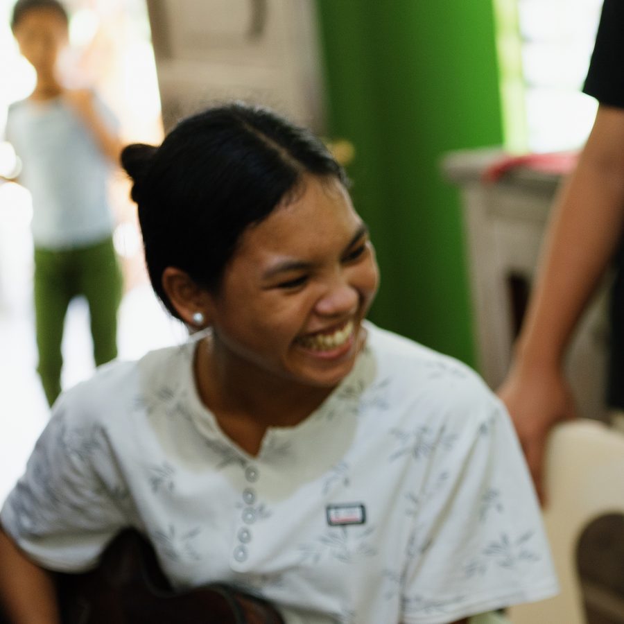 Two students laughing while playing guitar together