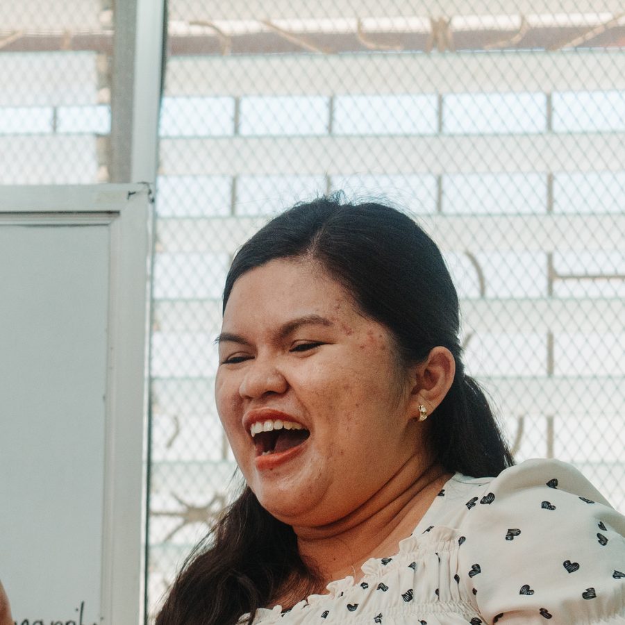A teacher laughing at the whiteboard